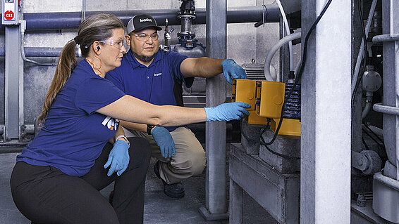 Two Leadec employees inspecting performance of a chem-tech pump.